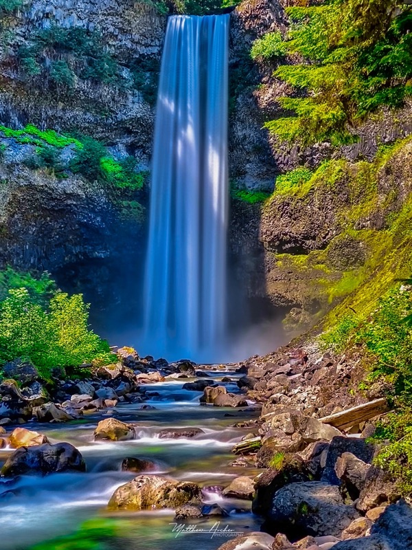 Brandywine Falls dropping into a rocky pool between moss-covered cliffs, the creek running over boulders below