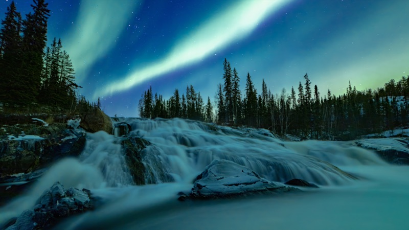 Aurora above a wide northern waterfall, the water drawn smooth by a long exposure — "Skyfall", a fine art print by Matthew Archer